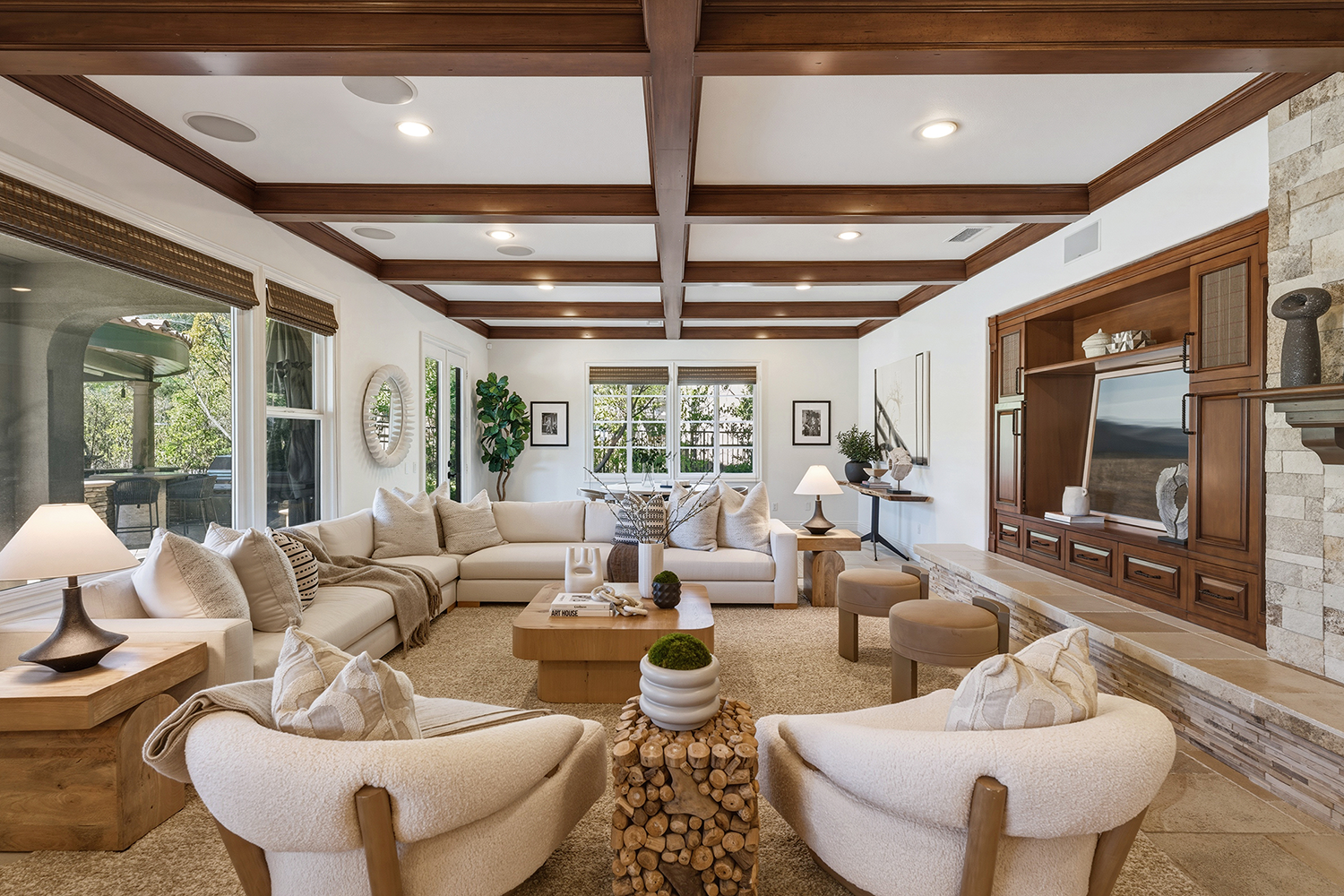 Staged living room with a wood-beamed ceiling and neutral furniture in a turnkey-ready Calabasas home