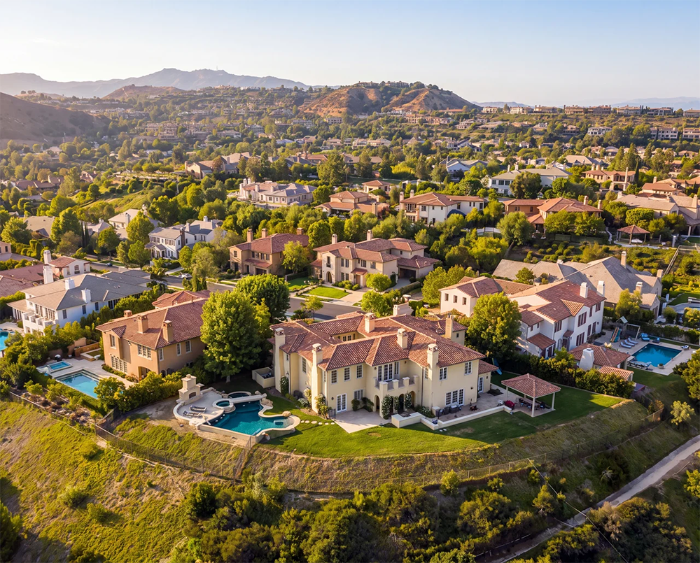 Aerial view of a gated Calabasas neighborhood with Mediterranean-style estates and pools